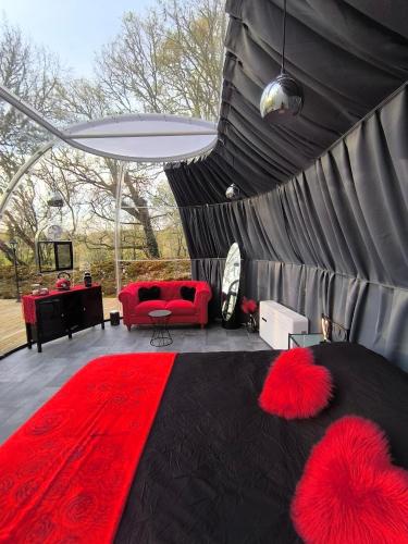 - un salon avec un canapé rouge et un tapis rouge dans l'établissement Bulle Love Passion & Spa, à Escamps