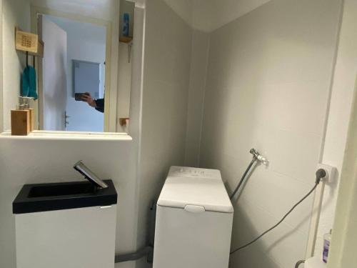 une personne prenant une photo de toilettes dans une salle de bains dans l'établissement Duplex familial 2 chambres avec piscine et parking, accès lac - FR-1-782-55, au Barcarès