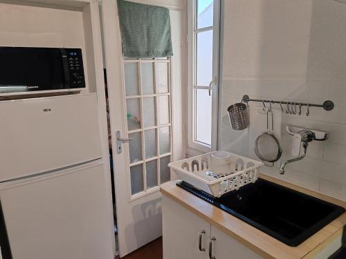 une petite cuisine avec un évier et une fenêtre dans l'établissement Spacieux appartement provençal - Mourillon - Beach 7 min à pieds, à Toulon