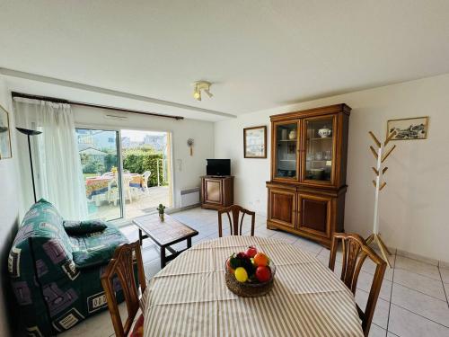 un salon avec une table avec un bol de fruits dessus dans l'établissement Appartement centre ville, au calme, jardin., à Quiberon