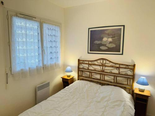 - une chambre avec un lit et deux lampes sur les tables dans l'établissement Appartement centre ville, au calme, jardin., à Quiberon