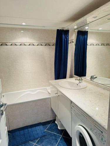 une salle de bain avec une baignoire et un lavabo et une baignoire dans l'établissement Appartement centre ville, au calme, jardin., à Quiberon