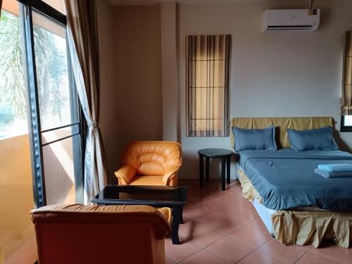 a bedroom with a bed and a chair and a window at jomtien summer villa,4BR in Jomtien Beach