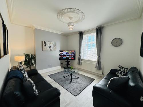 a living room with two couches and a tv at Sea Blue House, Cullercoats in Cullercoats