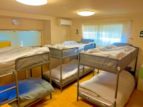 Postel nebo postele na pokoji v ubytování 駐車場あり男女混合ドミトリールーム出会いがある自然豊かな宿地域最安値無人チェックイン