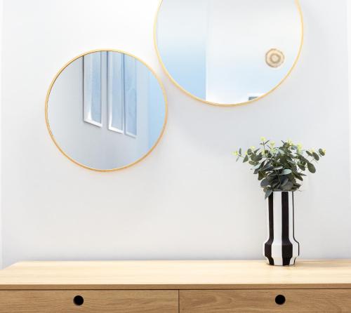 a mirror on a wall above a wooden dresser at Mnēmes Residence in Sozopoli
