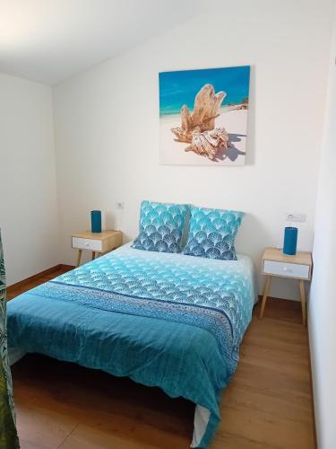 une chambre avec un lit avec une couette bleue dans l'établissement Maison proche centre-ville et baignade, à L'Aiguillon-la-Presqu'île