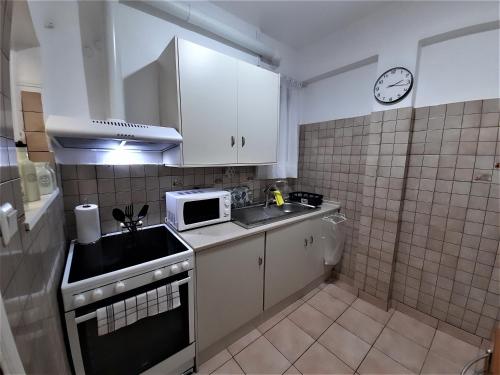 a small kitchen with a sink and a microwave at Port & Metro Escape Cozy Balcony Apartment in Piraeus in Piraeus