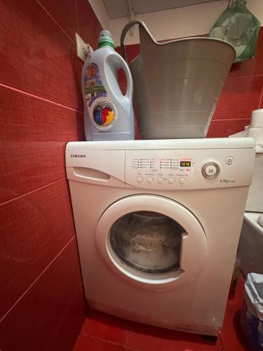 a washing machine in a bathroom with a detergent at Glori in Tbilisi City