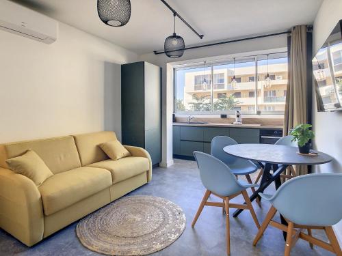 un salon avec un canapé et une table dans l'établissement Le Flamingo, à Balaruc-les-Bains