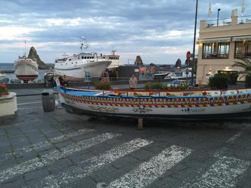a boat sitting on the ground next to a building at B&B Epos Acitrezza in Acitrezza