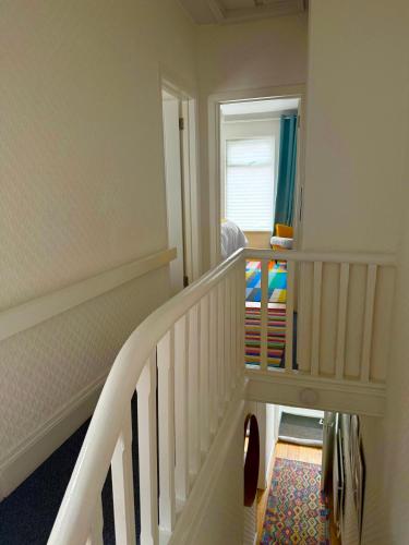 a white staircase with a window in a room at Bloom19 Traditional Belfast Entire House 10 mins from City Centre in Belfast
