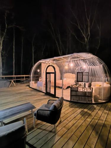 une yourte avec un canapé sur une terrasse en bois dans l'établissement Bulle de Morphée & Spa, à Escamps