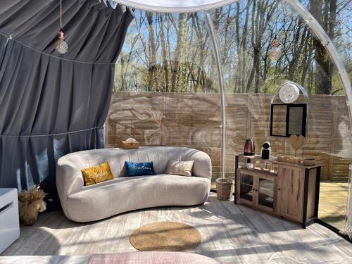 un salon avec un canapé et une table dans l'établissement Bulle de Morphée & Spa, à Escamps