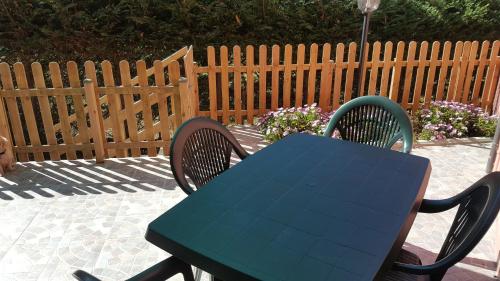 a blue table and chairs on a patio with a fence at Appartamenti Lucry in Procchio