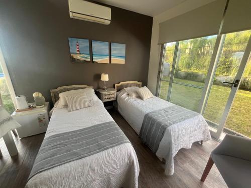 two beds in a room with a window at Suites de Portal in Paraná