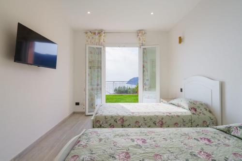 two beds in a room with a window at Stella di mare - appartamenti vista incantevole su Moneglia in Moneglia