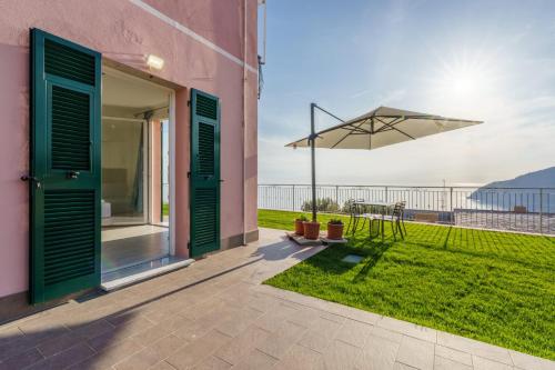 a patio with a table and an umbrella at Stella di mare - appartamenti vista incantevole su Moneglia in Moneglia