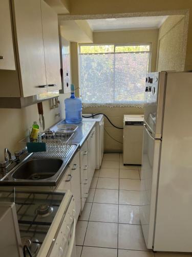 a small kitchen with a sink and a refrigerator at Elqui Antu in Vicuña