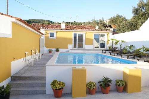 eine Villa mit einem Swimmingpool vor einem Haus in der Unterkunft Casal da FontAgrão in Rio Maior