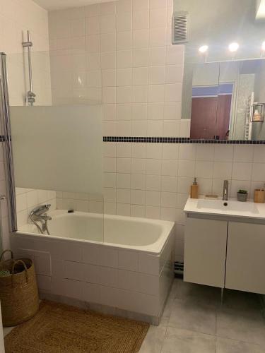 une salle de bain blanche avec une baignoire et un lavabo dans l'établissement Entre terre & Mer, à Saint-Brieuc