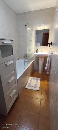 a white bathroom with a tub and a sink at El bosque NOMADA 2 in El Bosque