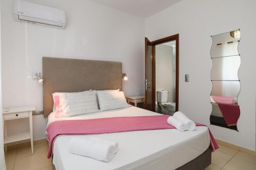 a bedroom with a large bed with towels on it at Cathrin Beachfront Villa in Plimmiri