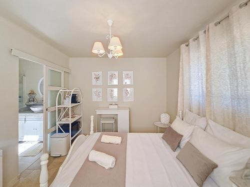 une chambre avec un grand lit blanc et une fenêtre dans l'établissement Chambre d'Hôtes 