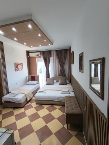 two beds in a room with a checkered floor at Becic Apartments in Ulcinj