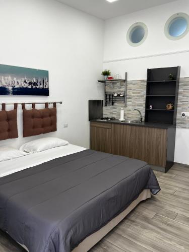 a bedroom with a large bed and a kitchen at Travel Home Pompei in Pompei