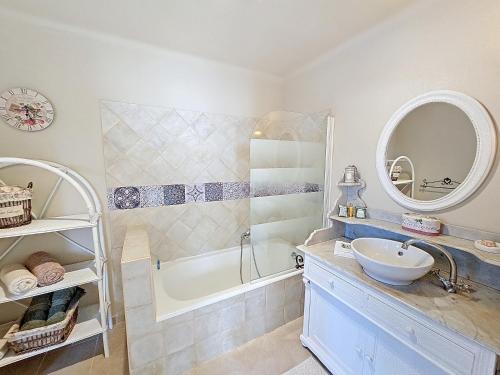 a bathroom with a sink and a tub and a mirror at Chambre d'Hôtes "Au Clos des Redonnets" avec Piscine in Saint-Cézaire-sur-Siagne