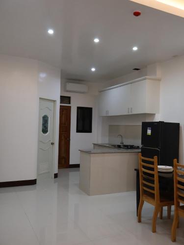 a kitchen with a counter and a table and chairs at Solcuerpo in Dauin