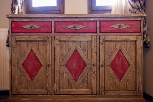 a wooden cabinet with red doors in a room at Matzato in Monodendri