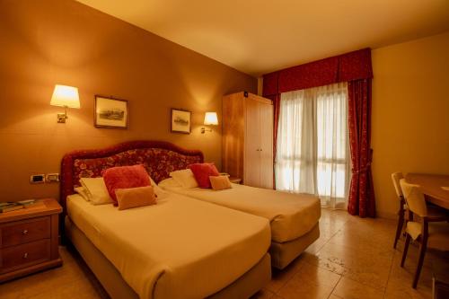 a hotel room with two beds and a window at Paradise Hotel & Wellness in Saint Vincent