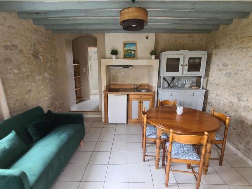 un salon avec un canapé et une table et une cuisine dans l'établissement Chambres d'Hôtes du Clos de la Touche, à Cheillé
