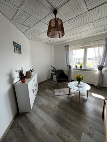 a living room with a table and a chair at Agroturystyka Pod Dzwonnicą - Beskidy in Zubrzyca Górna