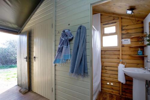 a bathroom with a sink and a towel on the door at Kittisford Barton at Lantern and Larks in Wellington