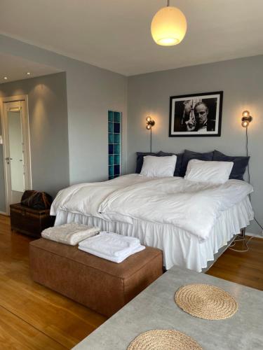 een slaapkamer met 2 bedden en een poef bij Frogner Gården Penthouse Terrasse in Oslo