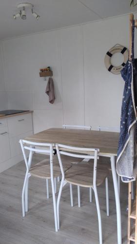 une table blanche et une chaise dans la cuisine dans l'établissement Gîte - La Ferme à la Plage, à Le Porge