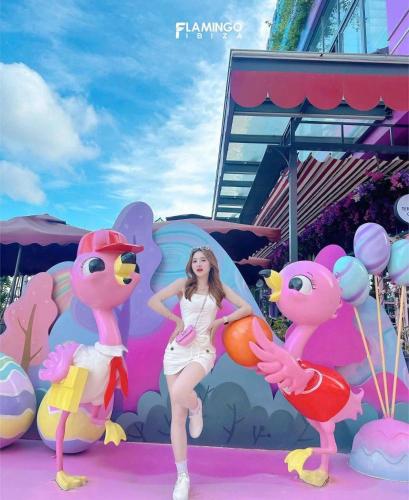 a woman standing in front of a bunch of pink flamingos at Flamingo Hai Tien in Hoằng Hóa