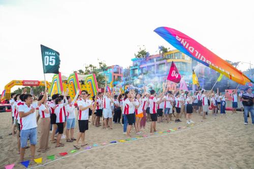 a group of people standing on the beach with flags at Flamingo Hai Tien in Hoằng Hóa