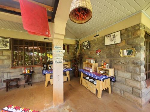 a restaurant with two tables and a stone wall at Edaala Comfort - B&B in Nairobi