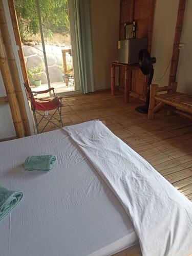 a white bed in a room with a window at El Eden Glamping cabañas Girardot in Girardot