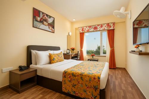 a hotel room with a bed and a window at Summit Namnang Courtyard & Spa Near Mg Marg in Gangtok