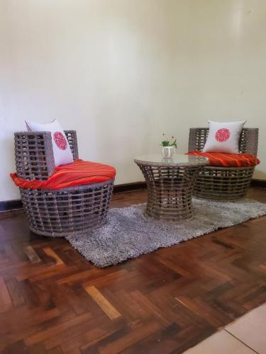 two wicker chairs and a table in a room at Edaala Comfort - B&B in Nairobi