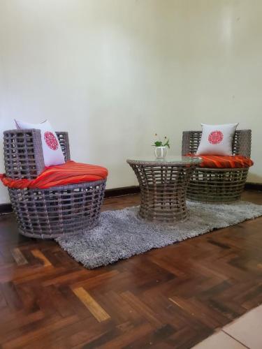 two wicker chairs and a table in a room at Edaala Comfort - B&B in Nairobi
