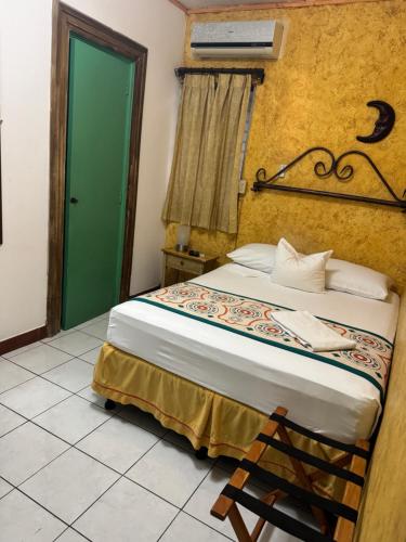 a bedroom with a bed with a green door at La Posadita de Bolonia in Managua