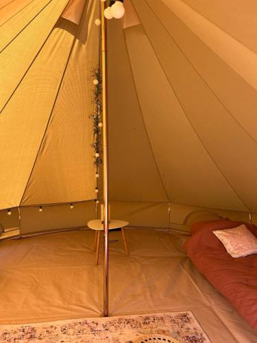 a tent with a table and a bed in it at Bell Tent in Elim