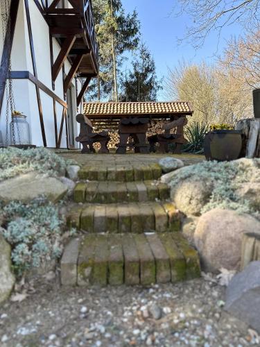 a park bench sitting next to a set of stairs at Ostoja Jeziorak Jezierzyce in Makowo