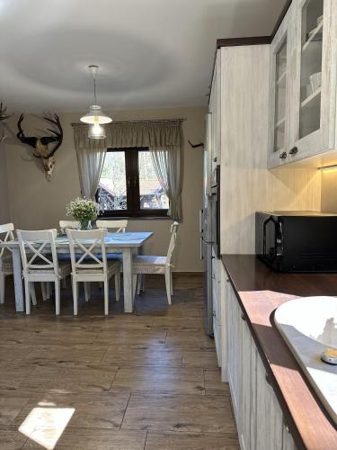 a kitchen and dining room with a table and chairs at Ostoja Jeziorak Jezierzyce in Makowo
